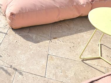 Photo du client : dalles de travertin Medium, tambourinées, assemblage romain, posées sur une terrasse, photo des marches d'escalier avec parterres de fleurs à gauche et à droite