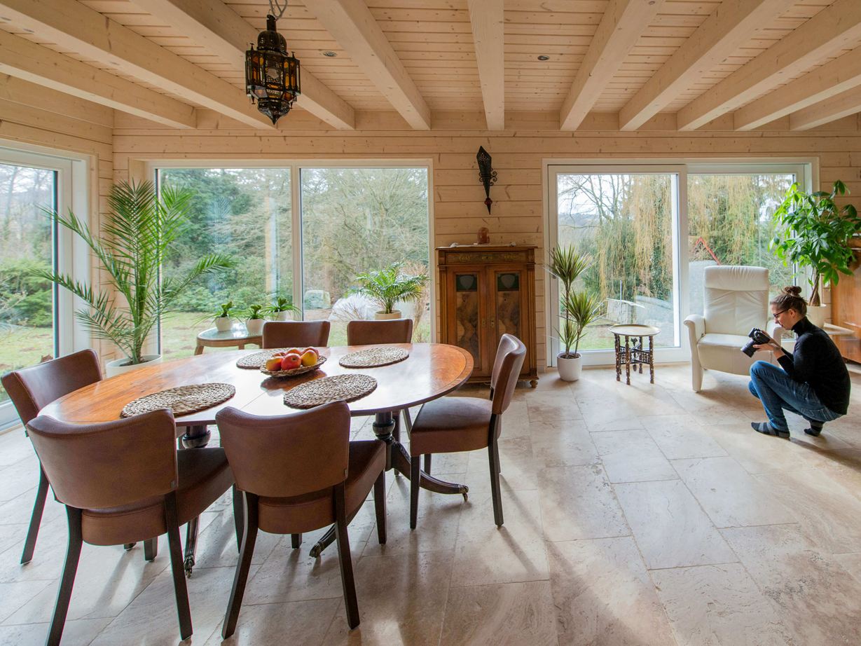 Salle à manger avec carreaux de travertin Rustique et femme prenant des photos du sol en pierre naturelle
