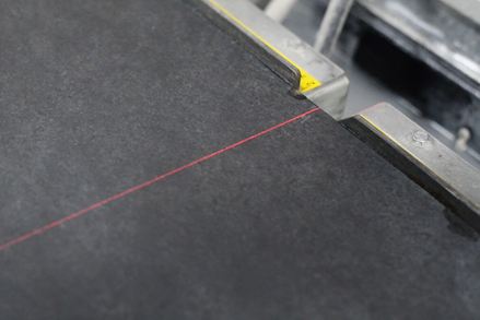 Ein Infrarot-Laser zeigt beim Schneiden die exakte Kantenlänge an