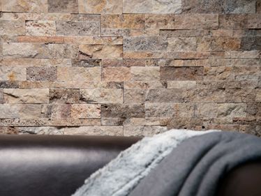 Sofa avec plaid et parement mural en travertin Scabas