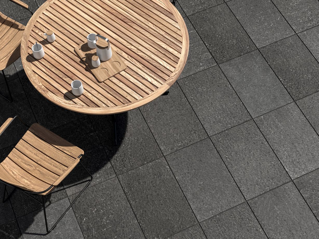Un aménagement extérieur moderne dans des teintes anthracite Terrasse avec dallage en basalte Takeda et meubles de jardin en bois