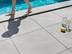 Quelqu'un marche pieds nus sur la plage de piscine en grès cérame imitation ardoise Alpine Grey