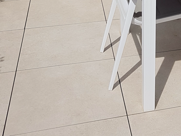 Le dallage Sevilla Cream vu de près avec pieds de meubles blancs