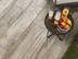 Une table avec boissons et fruits sur le dallage effet bois Indie Smoke