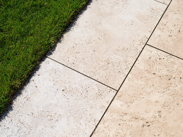 Le travertin Medium Line sur la terrasse avec deux bouteilles décoratives colorées