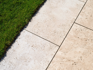 Le travertin Medium Line sur la terrasse avec deux bouteilles décoratives colorées