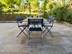 Terrasse en travertin marron Noce, table et chaises avec tournesol et vue sur le jardin