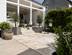 Dalles de terrasse en travertin Rustic, vue sur une partie de la terrasse, pilliers blancs en arrière plan