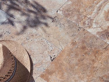 Le travertin Scabas sur une terrasse ensoleillée et un chapeau de paille