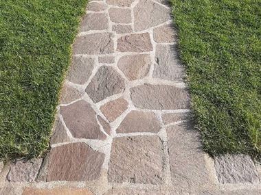 Un aménagement de jardin naturel et de qualité avec le porphyre Terra Les dalles polygonales en porphyre Terra entourée de gazon