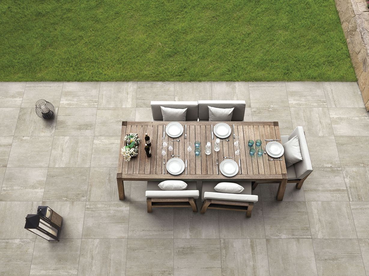 Transformez votre terrasse en coin de paradis moderne Une terrasse décorée du dallage à l'effet béton beige Concrete Sand et d'un salon de jardin