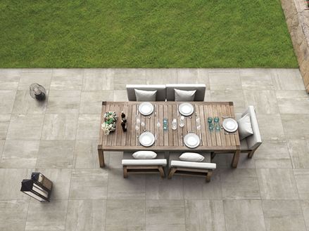 Une terrasse décorée du dallage à l'effet béton beige Concrete Sand et d'un salon de jardin