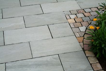 Délimitation entre le dallage en grès Kandla Grey et les bordures de massif