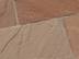 Gros plan sur les dalles en grès Modak aux tons rouges et beiges posées sur une terrasse