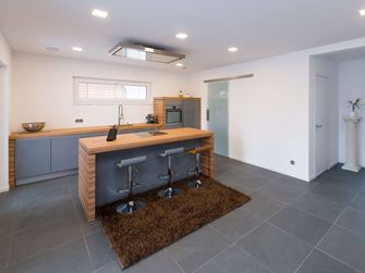 Cuisine avec éléments en bois et carreaux d'ardoise en gris doux comme revêtement de sol