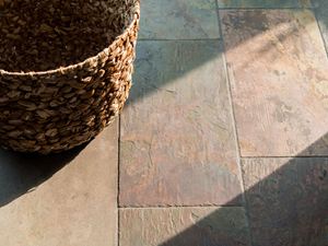 Une corbeille posée sur le carrelage en ardoise Peacock