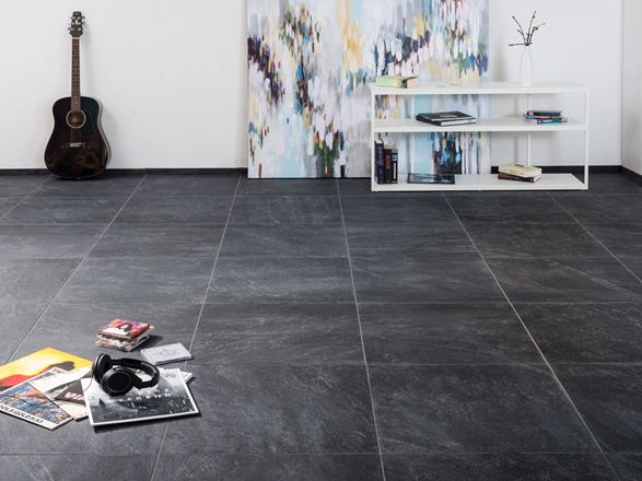 Carreaux modernes en grès cérame porcelainé d'aspect ardoise dans un salon avec une peinture moderne à l'arrière-plan et une guitare au mur.