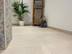 Salle de bain moderne avec meubles en bois, plante décorative et carrelage clair imitation pierre calcaire