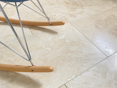 Carrelage en travertin Classic Light vu de près et pied de chaise