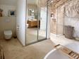Salle de bain avec sol en travertin Classic Light, baignoire, douche et toilettes
