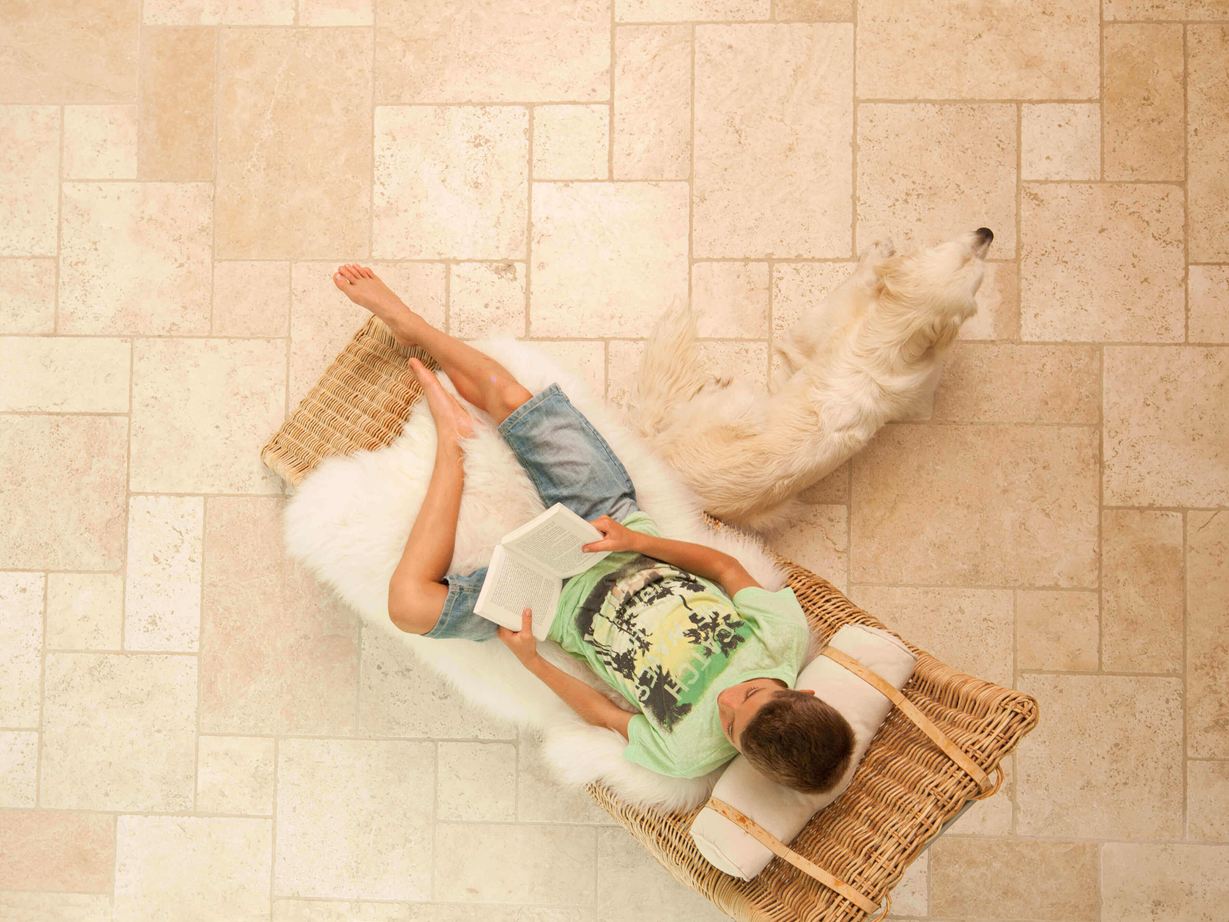 Le travertin opus pour un effet méditerranéen Garçon lit dans une chaise longue sur des carreaux de travertin clairs en opus romain