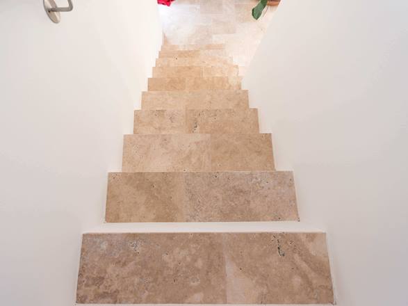 Treppe mit weissen Wänden und Travertin Medium als Trittplatten