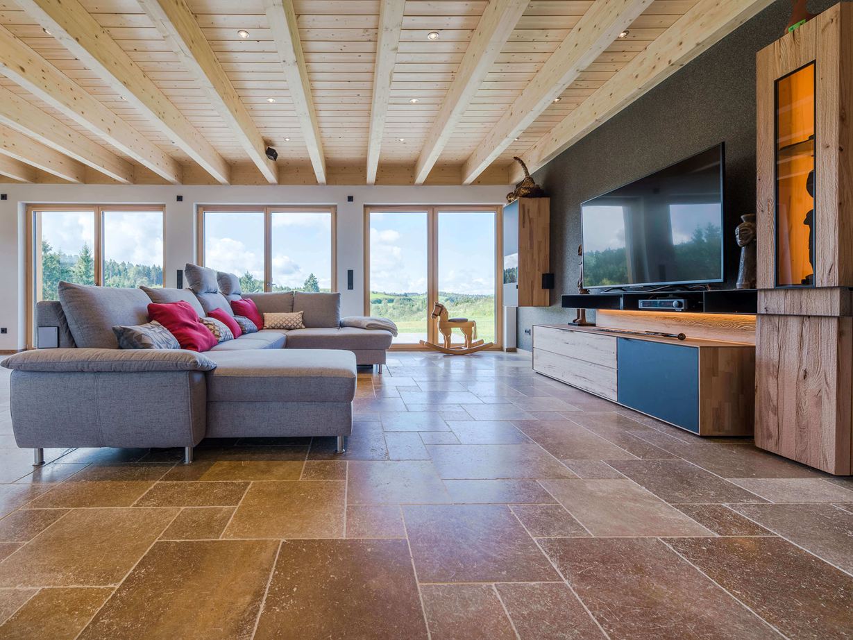 Une ambiance chaleureuse dans les tons noisette Salon avec sofa et revêtement de sol en travertin Noce dans les tons bruns