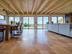 Grande salle à manger avec table, sofa et carrelage en travertin Noce