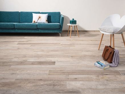 Salle de séjour avec carrelage d'aspect bois Indie Sky, chaise blanche et canapé vert foncé