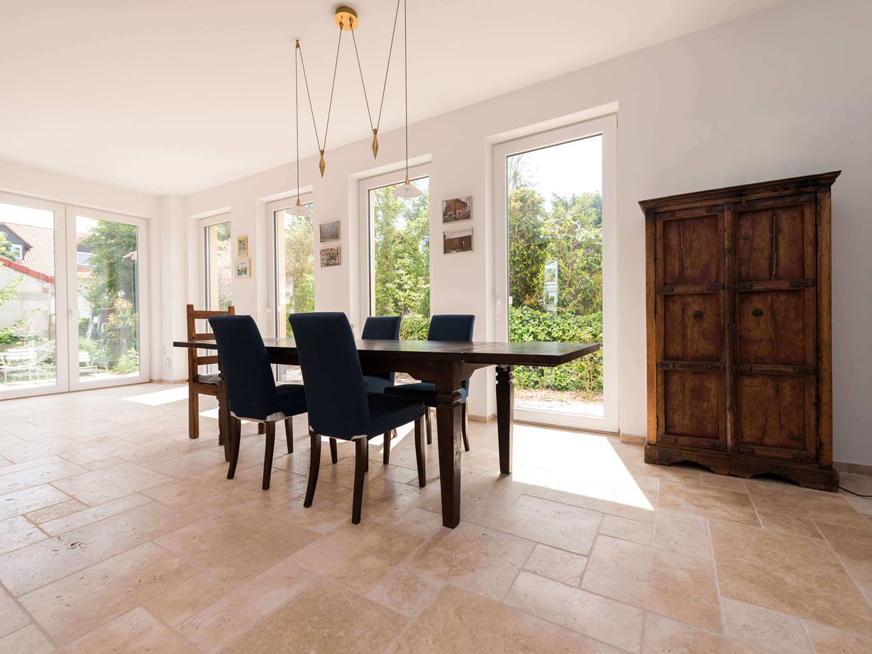 L'opus romain crée une ambiance rustique Salon et salle à manger avec mobilier rustique et carreaux de travertin