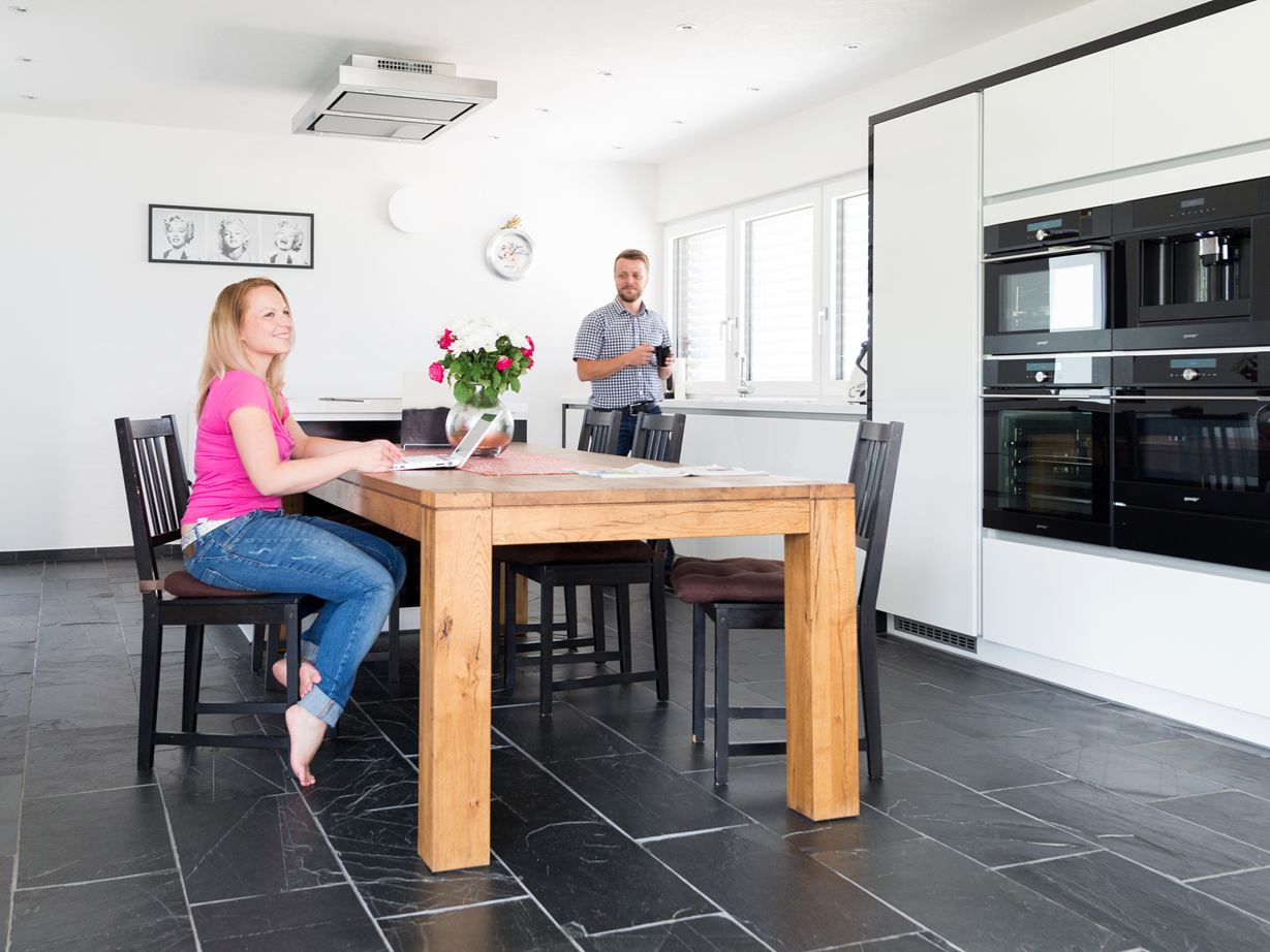 Une cuisine en carrelage en ardoise Black Rustic. Cuisine, ardoise Black Rustic et table en bois personnes à table