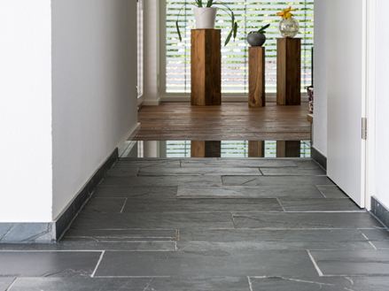 carrelage en ardoise, sol en bois et en verre avec plantes