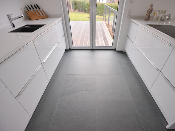 Une cuisine blanche avec des éléments en métal sur un sol en ardoise Grey Slate affinée