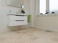 La salle de bain avec un sol en travertin et une déco blanche