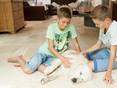 Deux enfants et un chien sur le carrelage en travertin Light.
