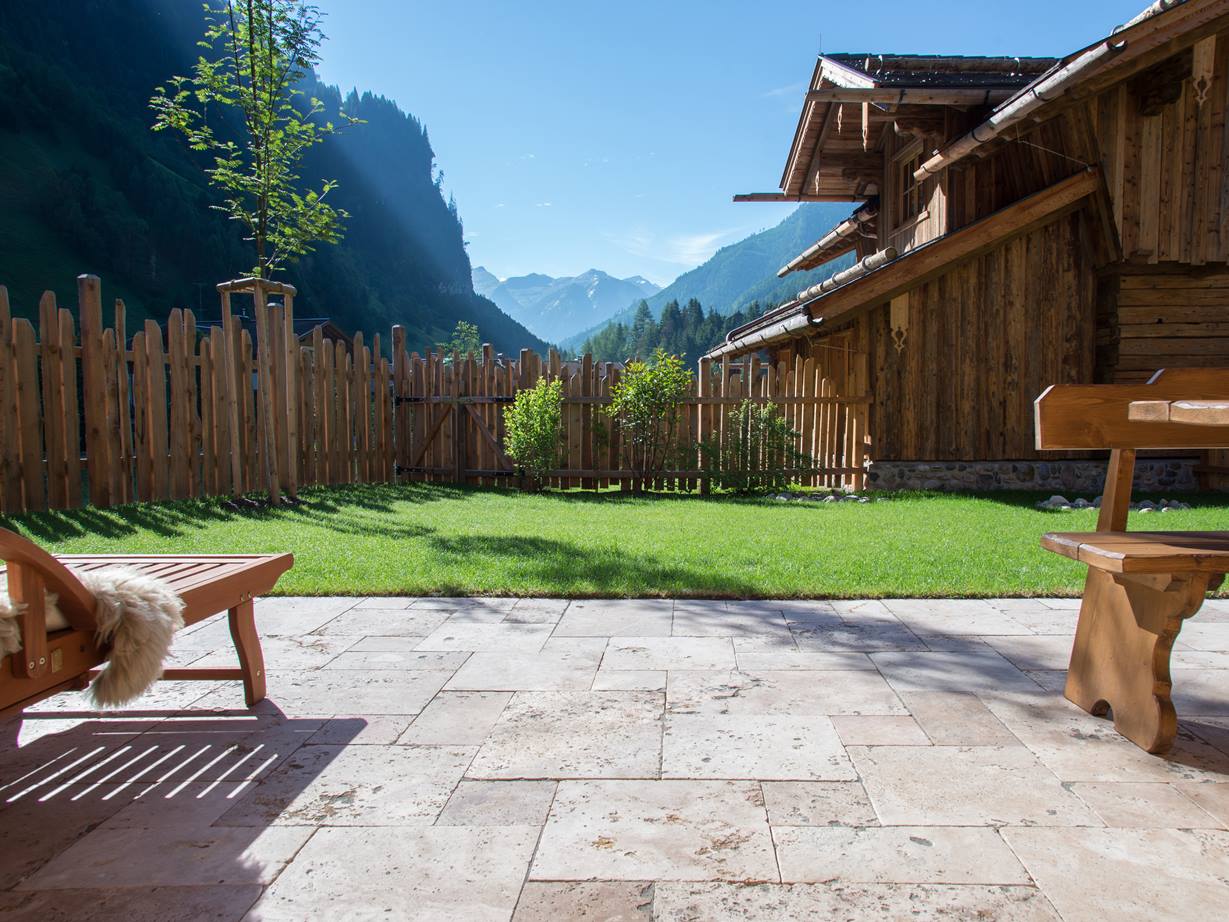 Une terrasse en travertin avec vue sur les Alpes... terrasse en travertin, chaise et table en bois avec vue sur alpes
