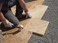 Une plaque de travertin est placée dans le lit de gravier