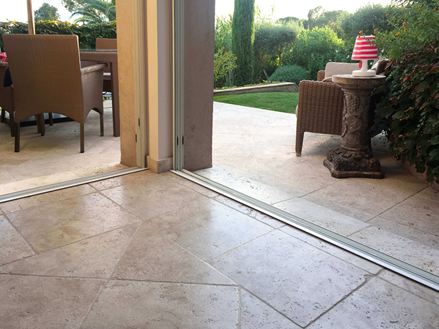 gros plan sur le sol en travertin pilier de la maison au milieu et en arrière plan une terasse encore en travertin