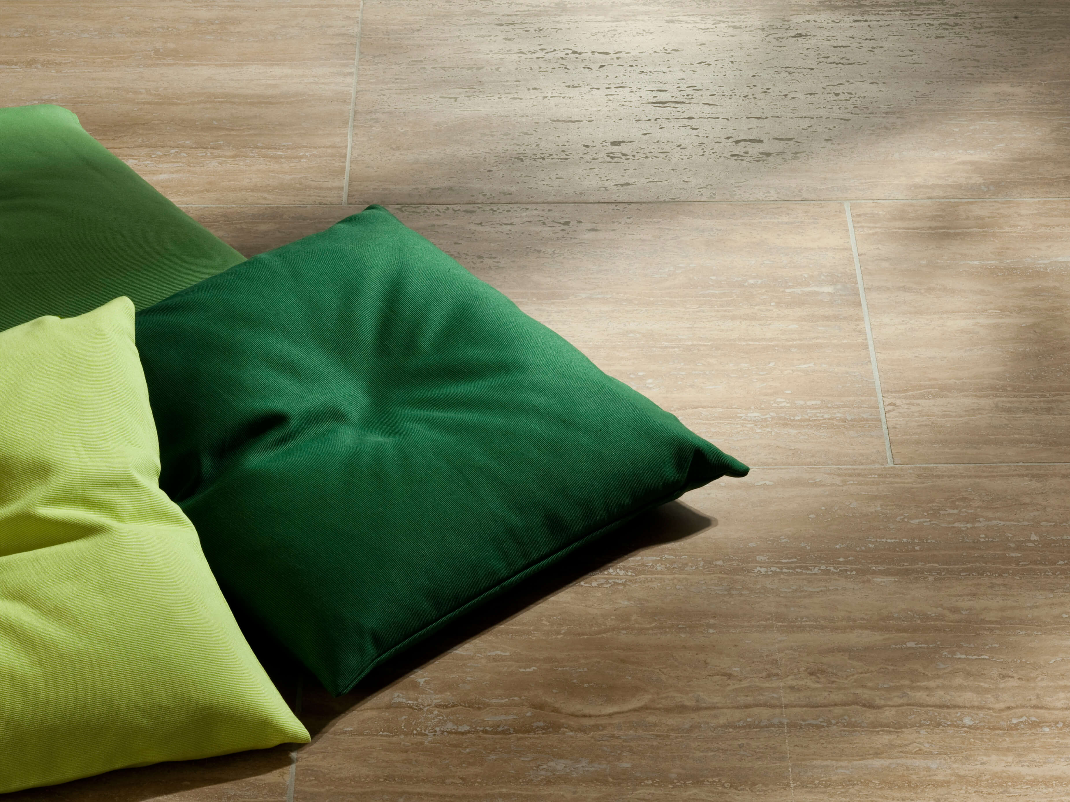 Fliesen Travertin Walnut gebändert und geschliffen mit drei grünen Kissen