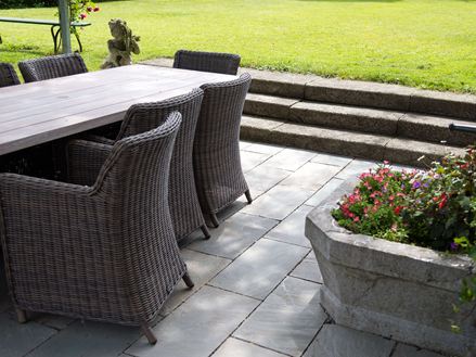 Rattanmöbel auf grauen Sandsteinplatten