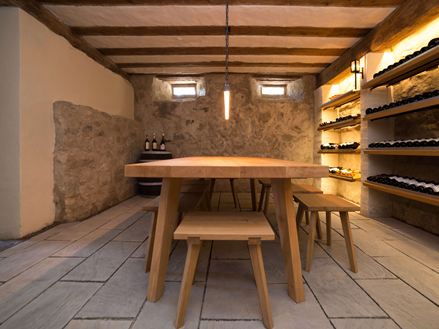 Cave à vin avec une grande table en bois et la pierre naturelle Kandla Grey en grès