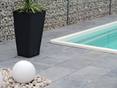 Bord de piscine avec palmier et plaque de pierre naturelle tombée pierre bleue azur