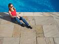 Soleil du soir sur les plaques de grès Yellow Mint avec une femme à la piscine