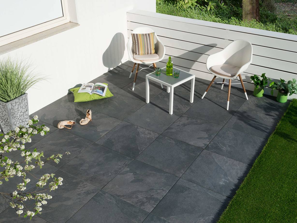 Terrasse avec mobilier moderne et dalles gris foncé en ardoise vue d'en haut.