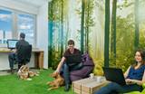 Mitarbeiter mit Hunden in Büro mit Wandtapete